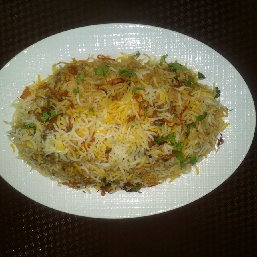 Fragrant Hyderabadi biryani plated and garnished with fried onions