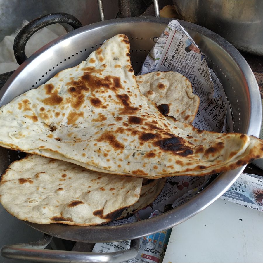 Fresh naan bread baked in a traditional clay tandoor